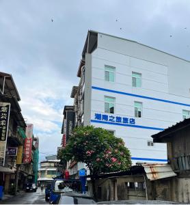 a white building with blue stripes on the side of a street at ChaoChaoINN in Chaozhou