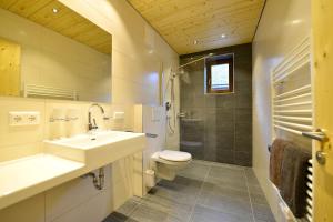 a bathroom with a sink and a toilet and a shower at Ferienwohnungen Plattner in Weissensee