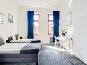 um quarto com 2 camas, uma secretária e 2 janelas em AS HOME Apartamenty Rynek 50 R505 em Breslávia