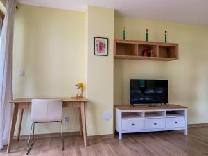 a living room with a tv and a table and a chair at Lovely forest escape, Mountain Lake complex in Smolyan