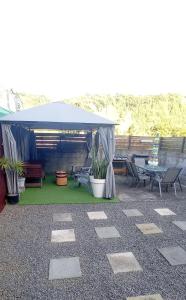 a blue canopy on a patio with chairs and plants at La maison Bras des Songes in Saint-André