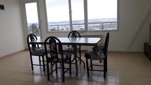 a dining room with a table and chairs and windows at MyR alojamiento in Ushuaia