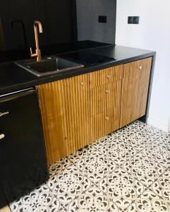a kitchen with a sink and a black counter top at Supreme Apartment in the City Center in Kraków