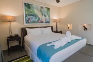 Un dormitorio con una gran cama blanca con un pájaro. en Piattelli Wine Resort en Cafayate