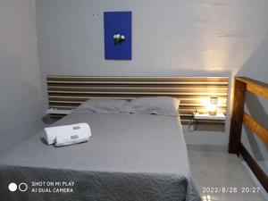 a bedroom with a large bed with a wooden headboard at Loft Pousada Sorriso in Sorriso