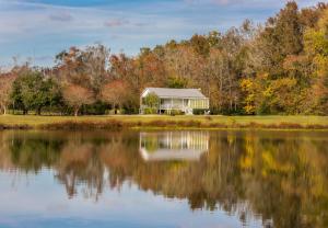 a house on the shore of a lake at Maison D'Memoire Bed & Breakfast Cottages in Rayne