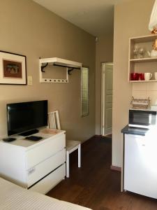 a bedroom with a bed and a dresser with a tv at Gedimino House in Vilnius