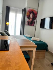 una habitación con una mesa y una pintura de una mujer en VARELA 30 Apartamentos, en Málaga