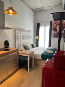 Habitación pequeña con cama, mesa y cocina en VARELA 30 Apartamentos, en Málaga