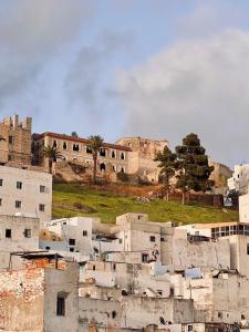 a group of white buildings with a castle in the background at Riad Amelia : Lalla Fatima Zohra Room in Tétouan