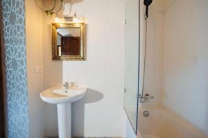 a bathroom with a sink and a mirror and a shower at Riad Amelia : Lalla Fatima Zohra Room in Tétouan +3 photos