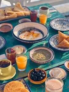 stół z talerzami jedzenia i napojów w obiekcie Riad Amelia : Lalla Fatima Zohra Room w mieście Tetuan