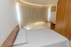 a small room with a bed and a window at Toulon Flat Service in Caldas Novas