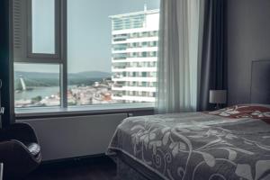 1 dormitorio con cama y ventana grande en VOiR Apartment, en Bratislava