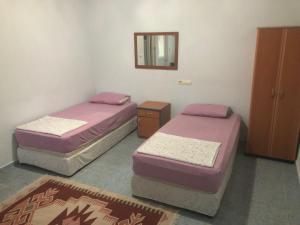 two twin beds in a room with a mirror at Ümit 2 Termal Apart Pansiyon in Pamukkale