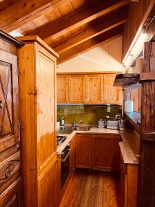 a kitchen with wooden cabinets and a sink at Chalet Blanc "Coeur Sapin" in Courmayeur