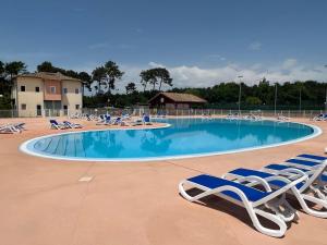 ein großer Pool mit Liegestühlen und einer Gruppe von Besuchern in der Unterkunft Villa Moana Soustons plage / Vieux-Boucau in Soustons