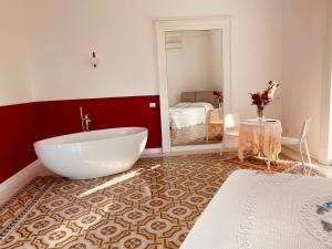 a bathroom with a large white tub in a room at Casa di Rita in Catania