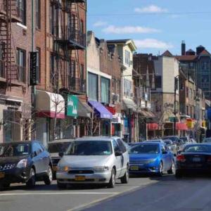 a busy city street with cars driving down the street at 67-26 Austin Cove near subway, all shops, restaurants! Separate Entrance in New York