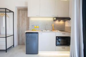 a kitchen with white cabinets and a sink at Lefkolia Retreat in Sivota