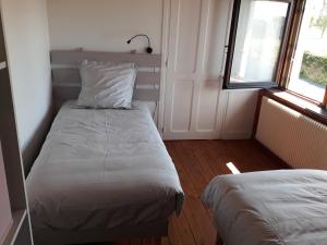 um quarto com 2 camas e uma janela em chez Jean-Marc et Colette em Le Molay-Littry