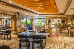 - un restaurant avec des tables et des chaises dans une salle dans l'établissement Hotel Faranda Express Puerta Del Sol Barranquilla, A Member of Radisson Individuals, à Barranquilla