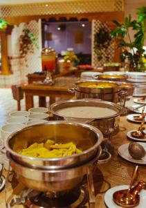 una cocina con varias ollas de comida en una mesa en Hotel Faranda Express Puerta Del Sol Barranquilla, A Member of Radisson Individuals, en Barranquilla
