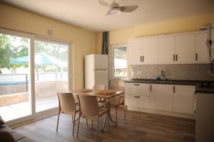 La cuisine est équipée d'une table, de chaises et d'un réfrigérateur. dans l'établissement Villa Verdi, à Dalyan