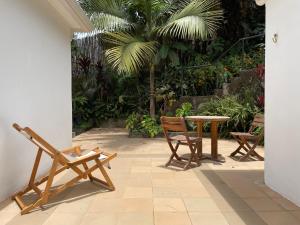 un patio con sillas, una mesa y palmeras en Casita Azul, en Salento