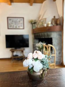 un vaso pieno di fiori rosa e bianchi su un tavolo di Chalet Blanc "Le Flocon" a Courmayeur
