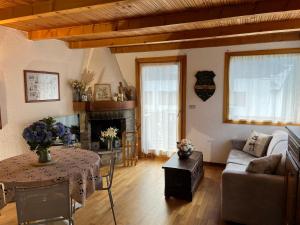 ein Wohnzimmer mit einem Sofa, einem Tisch und einem Kamin in der Unterkunft Chalet Blanc "Le Flocon" in Courmayeur
