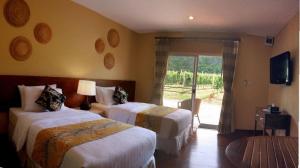 um quarto de hotel com duas camas e uma porta de vidro deslizante em GRANMONTE Wine Cottage em Phayayen