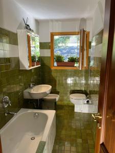 bagno con vasca, lavandino e servizi igienici di Chalet Blanc "Le Flocon" a Courmayeur
