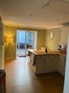 a kitchen with a counter and a clock on the wall at Pretty Ground Cottage in Comrie in Comrie