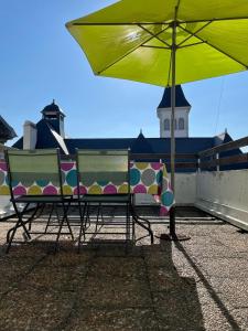 dwa krzesła i parasol na dachu w obiekcie Chez Fabien w mieście Pau