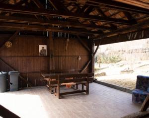 a wooden cabin with a bench and a table at Tulipános Vendégház in Szőlősardó