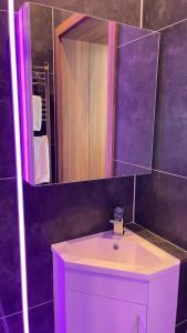 La salle de bains est pourvue d'un lavabo blanc et d'un miroir. dans l'établissement #5 TGHA Luxury One Bedroom Apartment in Athlone, à Athlone