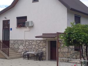 a table and chairs outside of a house at Apartman Šoljac in Perušić