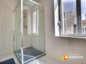 Maison de ville avec petite cour في Saint-Mihiel: دش زجاجي في حمام مع مرآة