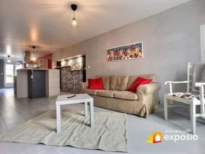 ein Wohnzimmer mit einem Sofa und einem Tisch in der Unterkunft Maison de ville avec petite cour in Saint-Mihiel