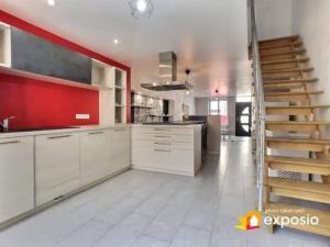 una gran cocina con armarios blancos y una escalera en Maison de ville avec petite cour, en Saint-Mihiel