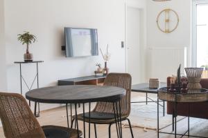 een woonkamer met een tafel en stoelen en een televisie bij African-Style Apartment in Koblenz