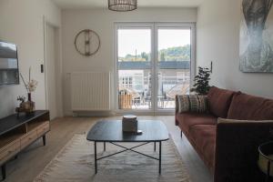 a living room with a couch and a coffee table at African-Style Apartment - stadtnah, Parkplatz, E-Ladestation für Auto & Fahrräder, Gitterbox für Fahrräder, Fitnessstudio in Koblenz +25 photos