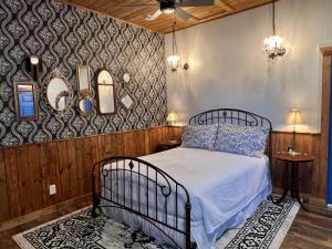 een slaapkamer met een bed en 2 tafels en spiegels bij The Russ House in Tombstone