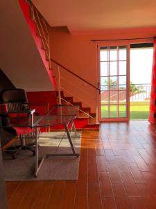 a living room with a glass table and stairs at Casa AIDA SEA VIEW in Relógio do Poiso