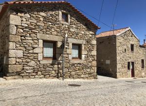 Casa de Xisto Ti Maria في Videmonte: مبنى حجري قديم بجدار حجري