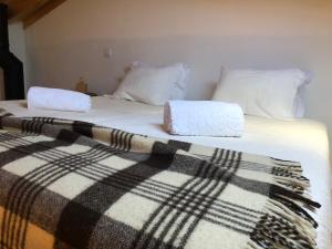 a bed with a blanket and two pillows on it at Casa de Xisto Ti Maria in Videmonte