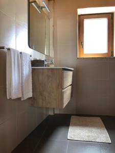 a bathroom with a sink and a mirror and towels at Casa de Xisto Ti Maria in Videmonte