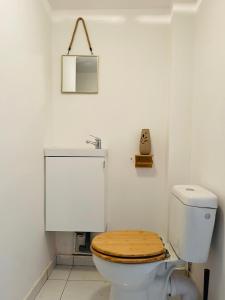 La salle de bains est pourvue de toilettes et d'un siège en bois. dans l'établissement BaLille, à Lille