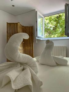 two stuffed animals sitting on a bed looking out a window at BaLille in Lille